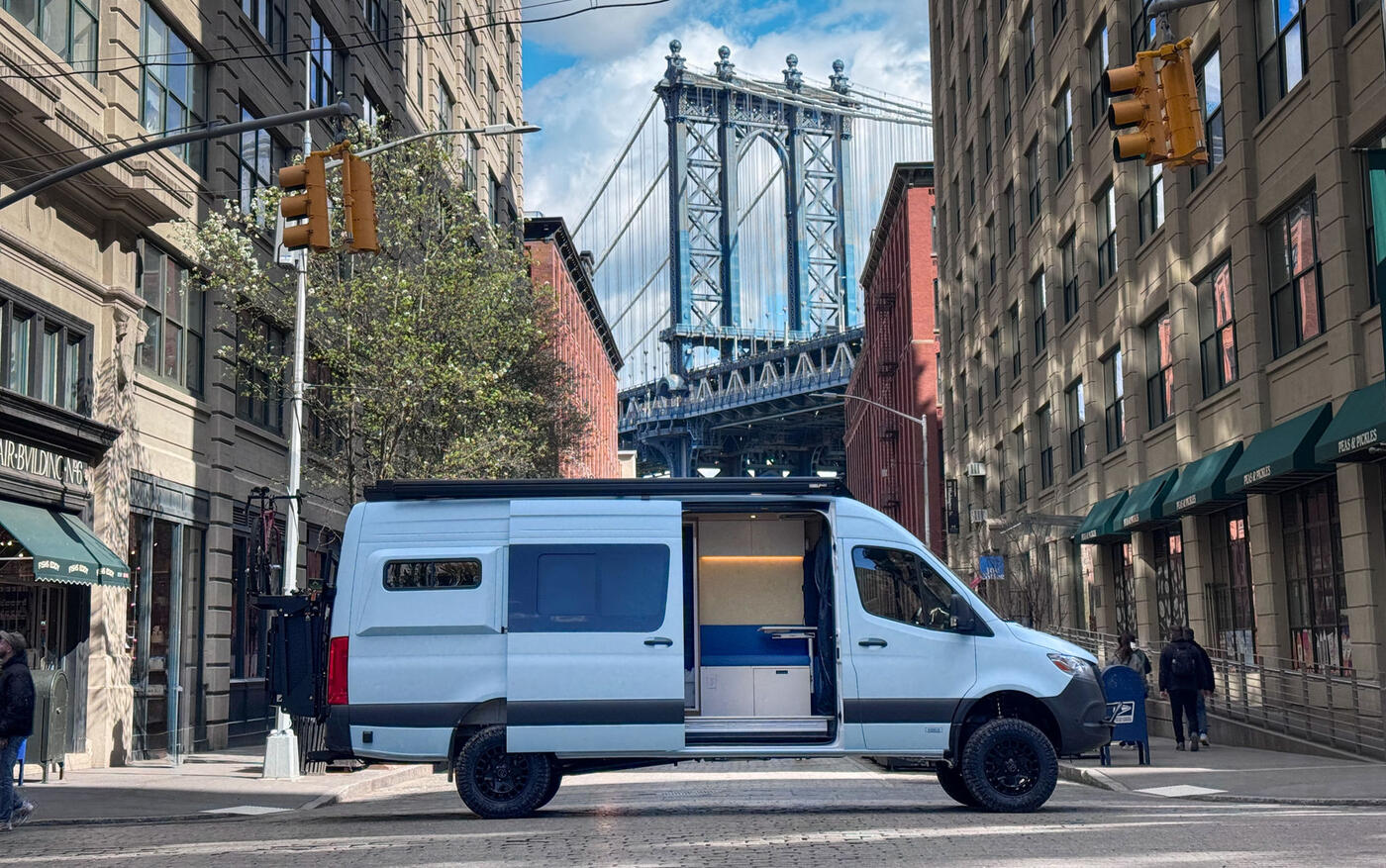 Custom Sprinter build on a Brooklyn street with the Manhattan Bridge behind, built by sister brand Brooklyn Campervans